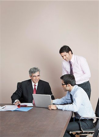 simsearch:630-07071502,k - Business executives looking at a laptop Stock Photo - Premium Royalty-Free, Code: 630-07071530