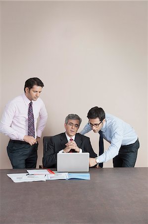simsearch:630-07071502,k - Business executives looking at a laptop Stock Photo - Premium Royalty-Free, Code: 630-07071531