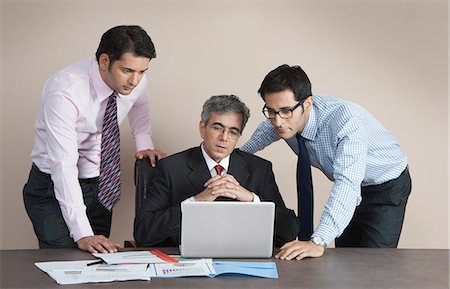 simsearch:630-07071502,k - Business executives looking at a laptop Stock Photo - Premium Royalty-Free, Code: 630-07071532