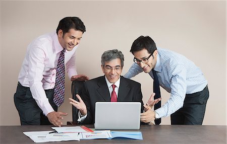 simsearch:630-07071502,k - Business executives looking at a laptop and smiling Stock Photo - Premium Royalty-Free, Code: 630-07071533