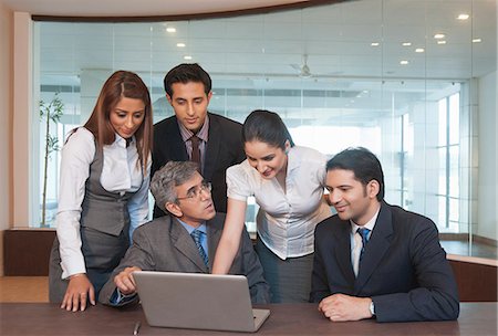 simsearch:630-07071502,k - Business executives looking at a laptop in a meeting Stock Photo - Premium Royalty-Free, Code: 630-07071578