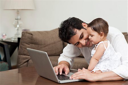 simsearch:6113-07543205,k - Man using a laptop with his daughter sitting with him Stock Photo - Premium Royalty-Free, Code: 630-07071664