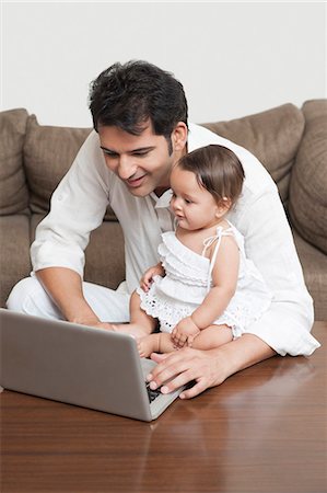 simsearch:6113-07543205,k - Man using a laptop with his daughter sitting with him Stock Photo - Premium Royalty-Free, Code: 630-07071661