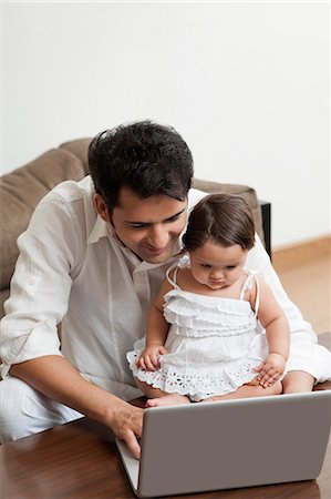 simsearch:6113-07543205,k - Man using a laptop with his daughter sitting with him Stock Photo - Premium Royalty-Free, Code: 630-07071662