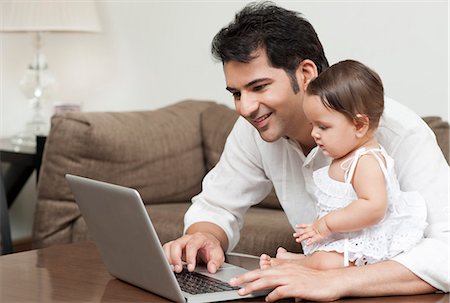 simsearch:6113-07543205,k - Man using a laptop with his daughter sitting with him Stock Photo - Premium Royalty-Free, Code: 630-07071663