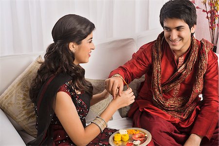 Teenage girl tying rakhi on her brother wrist Stock Photo - Premium Royalty-Free, Code: 630-07071726
