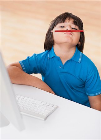 Boy balancing pencil on his face Stock Photo - Premium Royalty-Free, Code: 630-07071838