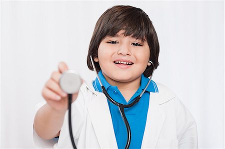 Boy holding a stethoscope and imitating like a doctor Stock Photo - Premium Royalty-Free, Code: 630-07071841