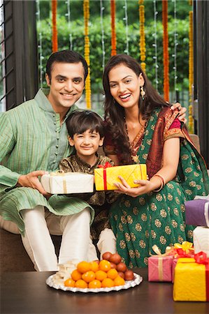 parents celebrating with child - Couple giving gifts to their son on Diwali Stock Photo - Premium Royalty-Free, Code: 630-07071983