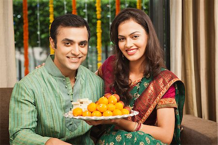 saree couples - Couple holding a plate of laddoo on Diwali Stock Photo - Premium Royalty-Free, Code: 630-07071991