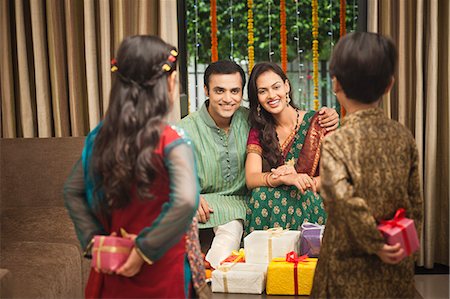 saree couples - Children hiding gifts with their parents on Diwali Stock Photo - Premium Royalty-Free, Code: 630-07071993