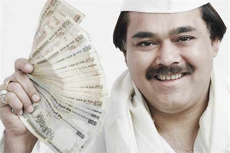 Portrait of a mature man holding Indian currency Stock Photo - Premium Royalty-Free, Code: 630-01077096