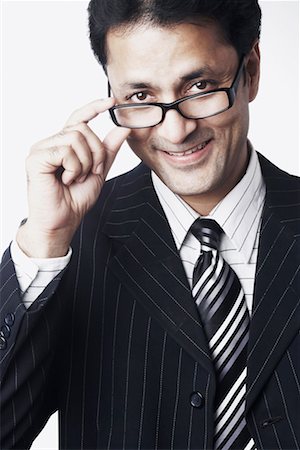 simsearch:640-01350815,k - Portrait of a businessman peeping over his eyeglasses Stock Photo - Premium Royalty-Free, Code: 630-01078451
