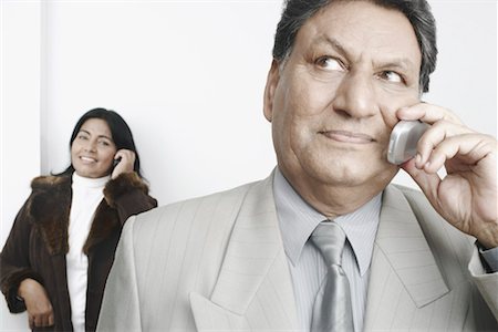 simsearch:630-01076466,k - Close-up of a businessman talking on a mobile phone with a businesswoman standing behind him Stock Photo - Premium Royalty-Free, Code: 630-01079385