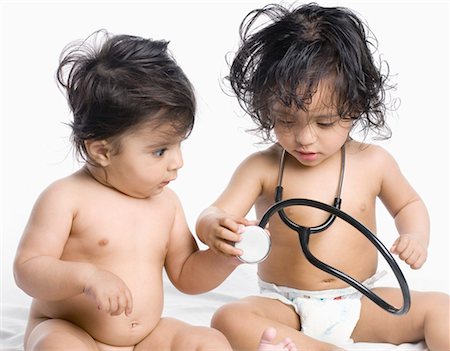Close-up of a baby boy and his sister playing with a stethoscope Stock Photo - Premium Royalty-Free, Code: 630-01079573