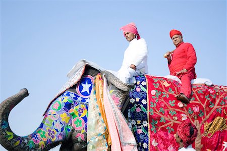 Low angle view of a young man and a senior man riding an elephant, Elephant Festival, Jaipur, Rajasthan, India Stock Photo - Premium Royalty-Free, Code: 630-01128461