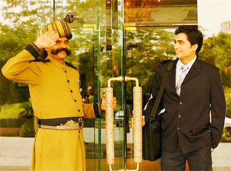 Portrait of a security guard saluting a businessman Stock Photo - Premium Royalty-Free, Code: 630-01128621