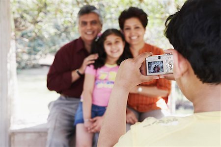 Rear view of a boy taking a picture of his grandparents and his sister Stock Photo - Premium Royalty-Free, Code: 630-01128936