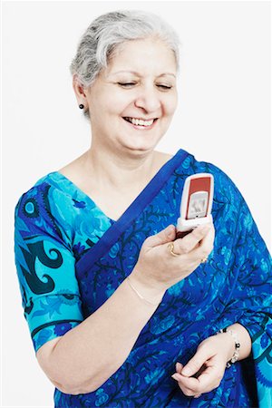 simsearch:630-01076466,k - Close-up of a mature woman smiling and looking at a mobile phone Stock Photo - Premium Royalty-Free, Code: 630-01130560