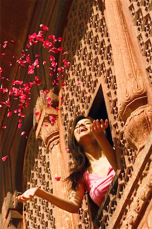simsearch:862-03711843,k - Low angle view of a young woman throwing rose petal from a window Agra Fort, Agra, Uttar Pradesh, India Stock Photo - Premium Royalty-Free, Code: 630-01131099