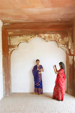 simsearch:700-01200131,k - Young woman taking a photograph of her friend standing in a prayer position, Agra Fort, Agra, Uttar Pradesh, India Stock Photo - Premium Royalty-Free, Code: 630-01131509