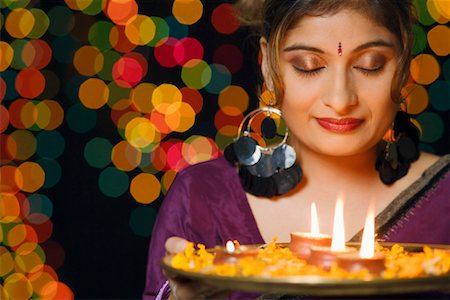 Close-up of a young woman holding a plate of religious offerings Stock Photo - Premium Royalty-Free, Code: 630-01192401