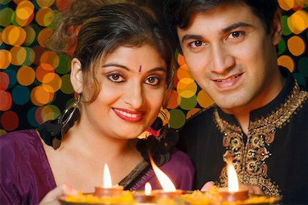 simsearch:700-00195618,k - Portrait of a young couple holding a plate of religious offerings and smiling Stock Photo - Premium Royalty-Free, Code: 630-01192403