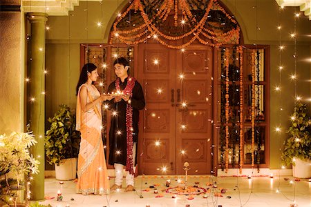 Young couple holding oil lamps in a plate Stock Photo - Premium Royalty-Free, Code: 630-01192768