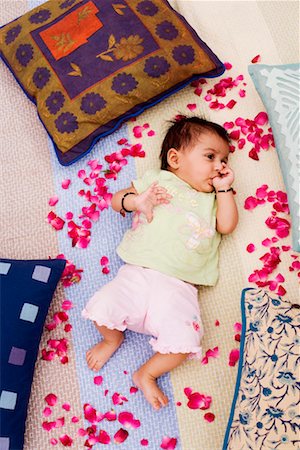 High angle view of a baby girl lying on the bed and sucking his thumb Stock Photo - Premium Royalty-Free, Code: 630-01192947