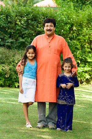 simsearch:630-01296751,k - Portrait of a mature man with his two daughters standing in a garden and smiling Stock Photo - Premium Royalty-Free, Code: 630-01296749