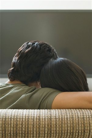 romantic couples anonymous - Rear view of a man and a woman sitting on a couch and watching television Stock Photo - Premium Royalty-Free, Code: 630-01490470