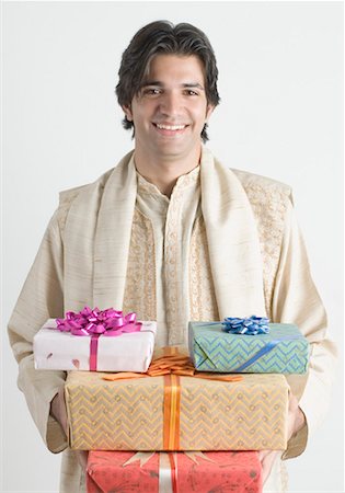 Portrait of a young man holding presents Stock Photo - Premium Royalty-Free, Code: 630-01490511