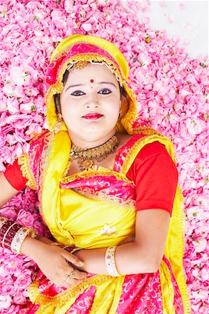 rajasthan clothes for women - Portrait of a young woman in a stage costume and lying on a bed of rose petals Stock Photo - Premium Royalty-Free, Code: 630-01490593