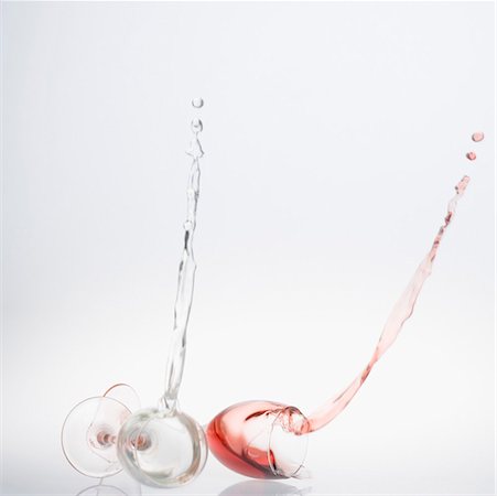 Close-up of wine spilling from two wine glasses Stock Photo - Premium Royalty-Free, Code: 630-01490792