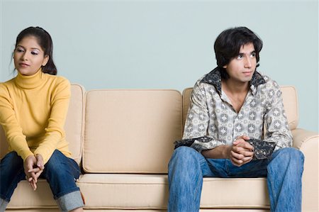 Young man and a young woman sitting on a couch Stock Photo - Premium Royalty-Free, Code: 630-01490874