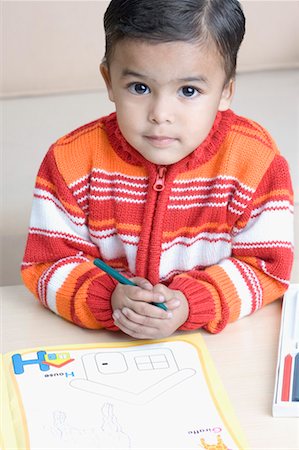 High angle view of a boy holding a crayon near a coloring book Foto de stock - Sin royalties Premium, Código: 630-01491046