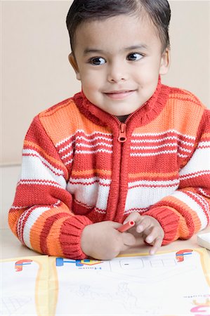Close-up of a boy smiling and holding a crayon Foto de stock - Sin royalties Premium, Código: 630-01491048
