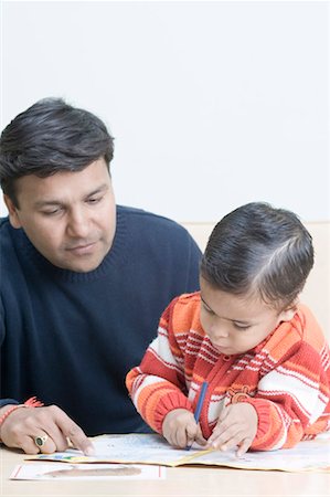 Mid adult man teaching his son to draw Stock Photo - Premium Royalty-Free, Code: 630-01491051