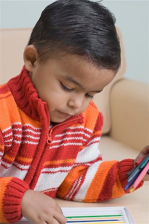 Close-up of a boy choosing a crayon Foto de stock - Sin royalties Premium, Código: 630-01491052