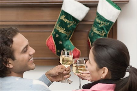 Rear view of a young couple toasting with wine glasses and smiling Stock Photo - Premium Royalty-Free, Code: 630-01491273