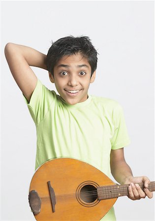 Portrait of a boy holding a guitar Stock Photo - Premium Royalty-Free, Code: 630-01491555