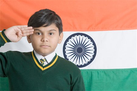 Portrait of a schoolboy saluting in front of an Indian flag Stock Photo - Premium Royalty-Free, Code: 630-01491787