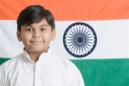 Portrait of a boy smiling in front of the Indian flag Stock Photo - Premium Royalty-Free, Code: 630-01491788