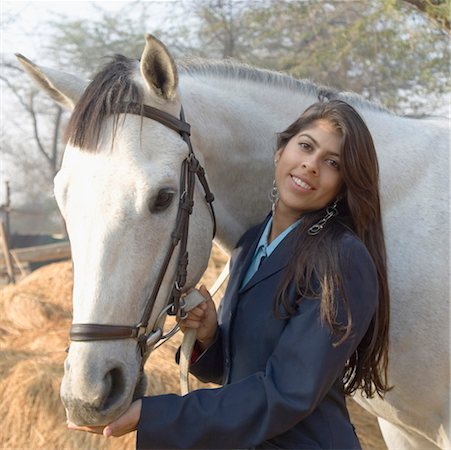 Portrait d'une jeune femme debout avec un cheval et souriant Photographie de stock - Premium Libres de Droits, Code: 630-01491830