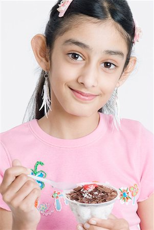 Portrait of a girl eating ice cream with a spoon Stock Photo - Premium Royalty-Free, Code: 630-01492253