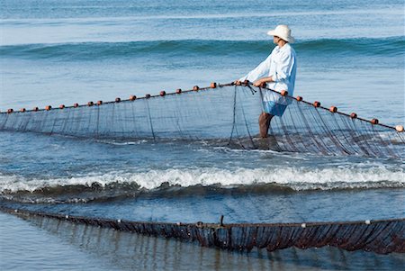 Side profile of a man pulling a fishing net on the beach, Morjim Beach, Goa, India Stock Photo - Premium Royalty-Free, Code: 630-01492481