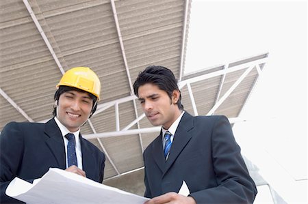 Two architects discussing a blueprint at a construction site Stock Photo - Premium Royalty-Free, Code: 630-01492512