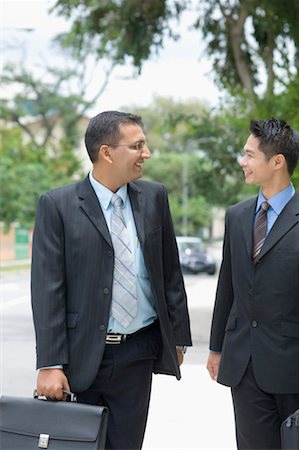 Two businessmen looking at each other and smiling Stock Photo - Premium Royalty-Free, Code: 630-01492666