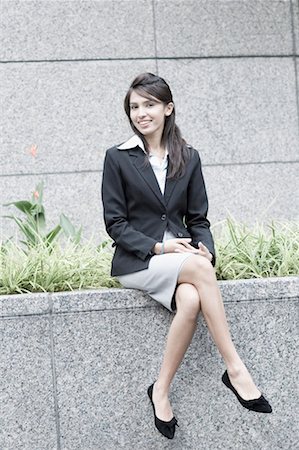 full business suit - Portrait of a businesswoman sitting on a ledge Stock Photo - Premium Royalty-Free, Code: 630-01492774