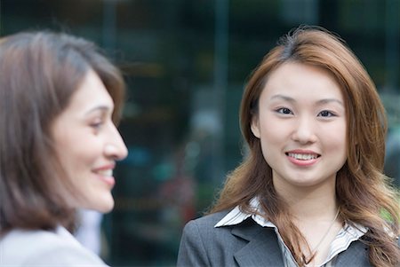 Portrait of a businesswoman smiling with another businesswoman Foto de stock - Sin royalties Premium, Código: 630-01492815